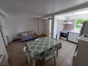 a living room with a table and a kitchen at Sakura No Ie in San Carlos de Bariloche