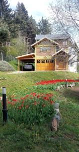 a house with a bunch of flowers in front of it at Sakura No Ie in San Carlos de Bariloche