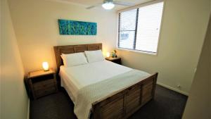 a bedroom with a bed with two night stands and a window at Esplanade View Unit 3 Wollombi in Caloundra