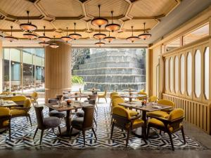 a restaurant with tables and chairs and a large window at Dusit Thani Bangkok in Bangkok