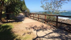 a sidewalk next to a fence next to the beach at Esplanade View Unit 3 Wollombi in Caloundra