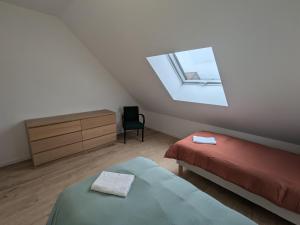 ChaingyにあるGîte 1 Les Ratys : charme, calme et confort près d'Orléans - FR-1-590-523の屋根裏のベッドルーム(ベッド2台、窓付)
