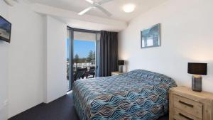 a hotel room with a bed and a balcony at Centrepoint Unit 27 in Caloundra