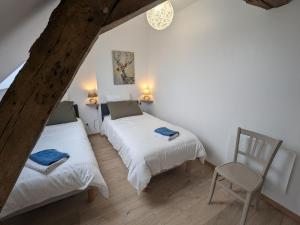 a room with two beds and a chair in it at Charmant gîte près d'Orléans avec jardin privatif et parking - FR-1-590-524 in Chaingy