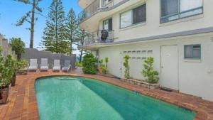 una piscina frente a una casa en Campbells Cove Unit 12, en Caloundra