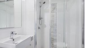 a white bathroom with a sink and a shower at Centrepoint Unit 27 in Caloundra +7 photos