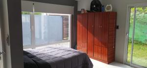 Casa la florida في مار ديل بلاتا: غرفة نوم بسرير وخزانة ونافذة