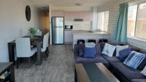 a living room with a couch and a kitchen at Solaris Court Unit 5 in Caloundra