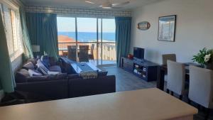 a living room with a couch and a view of the ocean at Solaris Court Unit 5 in Caloundra