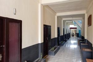 a hallway of a building with black and white at RedDoorz Syariah at Penginapan Queen Sungai Penuh in Sungaitutung +17 photos