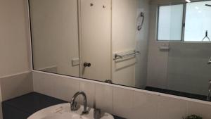 a bathroom with a sink and a large mirror at Spinnaker Seas Unit 2 in Caloundra +3 photos