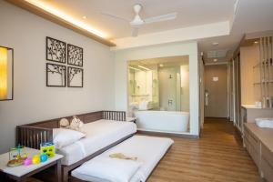ein Wohnzimmer mit einem Bett und einer Badewanne in der Unterkunft Katathani Phuket Beach Resort - SHA Extra Plus in Kata Beach
