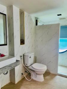 a bathroom with a white toilet and a sink at Andaman Beach Resort by Zodiac in Ko Lipe