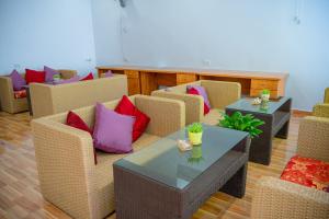 a living room with wicker chairs and tables with pink pillows at Tam Coc Sunshine Hostel in Vũ Lâm