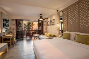 ein Schlafzimmer mit Bett und ein Wohnzimmer in der Unterkunft Katathani Phuket Beach Resort - SHA Extra Plus in Kata Beach