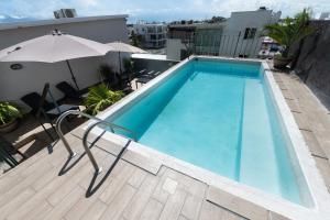 a swimming pool on top of a building with an umbrella at Boca Inn Hotel & Suites in Veracruz