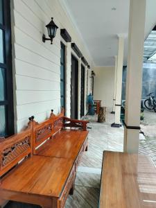a wooden bench sitting on the side of a house at Sulfat Indah home stay syariah in Ngadipuro