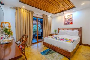 a bedroom with a bed and a desk and a table at GIARDINO ROMANTICO in Dumaguete +46 photos