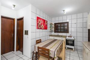 a small kitchen with a table and a stove at 5 Pessoas | Praia Armação | Beto Carrero in São Lídio +3 photos