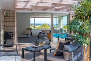 a living room with a couch and a table at Tuis and Pools - Lake Taupo Holiday Home in Taupo