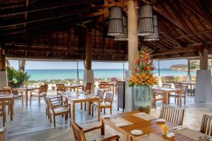 a restaurant with tables and chairs and a view of the ocean at Katathani Phuket Beach Resort - SHA Extra Plus in Kata Beach