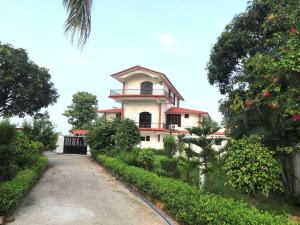 un bâtiment avec une tour d'horloge sur le côté d'une route dans l'établissement Hotel O Corbett Farm Homestay, à Rāmnagar 13 autres photos