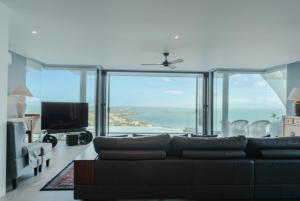 a living room with a couch and a view of the ocean at Seaview Dreamscape Villa in Amphoe Koh Samui