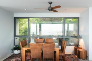 a dining room with a table and chairs and a large window at Seaview Dreamscape Villa in Amphoe Koh Samui