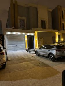 リヤドにあるBoulevard Villa 312 mの夜間のガレージ前に駐車した車2台