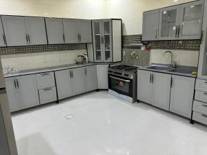 リヤドにあるBoulevard Villa 312 mの広いキッチン(白いキャビネット、コンロ付)