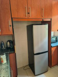 un réfrigérateur dans une cuisine avec des armoires en bois dans l'établissement Rozza Self-catering Accommodation, à UTW