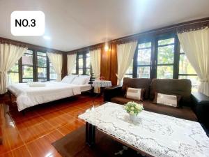 una grande camera da letto con un letto e un divano di Sleep Home Khaoyai a Pak Chong