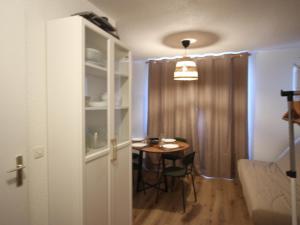 a room with a table and a dining room at Studio confortable à Chamrousse avec balcon et cuisine équipée - FR-1-340-283 in Chamrousse