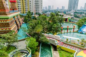 a water park in a city with a water slide at Simply and Cozy Pool View 2BR at Great Western Apartment By Travelio in Pumpangsineng