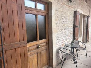 イジェにあるLa Tour Mailly - 3 pièces tout confortのパティオの隣にテーブルと椅子が置かれた木製のドア