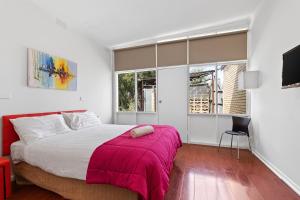 a bedroom with a large bed with a pink blanket at TORRUMBARRY MOTEL in Torrumbarry +77 photos