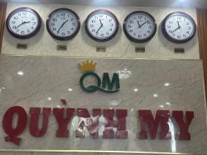 vier Uhren an einer Wand über einem Ladenschild in der Unterkunft Quynh My Motel in Cần Thơ