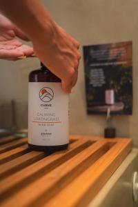 a person is holding a bottle of wine on a counter at Curve Villas Boutique Resort in Tanah Lot