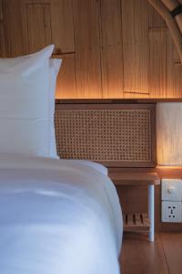 a bedroom with a bed and a wooden cabinet at Curve Villas Boutique Resort in Tanah Lot +19 photos