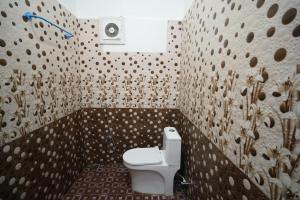 a bathroom with a toilet and a wall with dots at Cayzen in Chennai