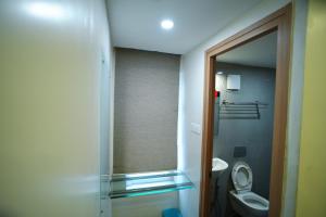 a bathroom with a toilet and a glass shower door at RAAJ PEARL in Chennai