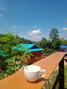 a coffee cup sitting on a wooden table at บ้านย่าเขาค้อ in Ban Khao Ya Nua +13 photos