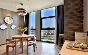 une salle à manger avec une table et une grande fenêtre dans l'établissement Mehood Lestie, Nantong Tongzhou New Century Avenue, à Nantong 19 autres photos