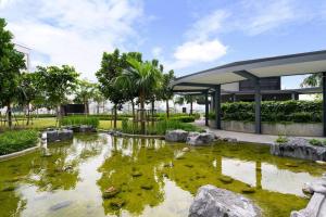 a pond in front of a building with ducks in it at Lumi Tropicana Muji Concept in Petaling Jaya