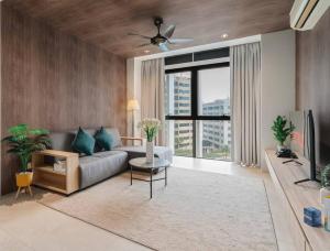 a living room with a couch and a large window at Lumi Tropicana Muji Concept in Petaling Jaya