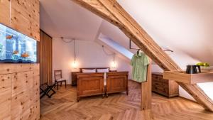 an attic room with wooden floors and wooden beams at Niedermairhof in Brunico