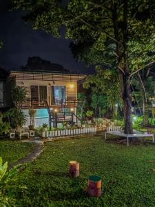 una casa con un albero in giardino di notte di Sleep Home Khaoyai a Pak Chong