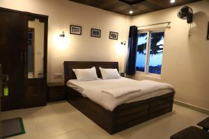 a bedroom with a large bed with a window at Himalayan view stay - Pahado wala ghar in Mussoorie
