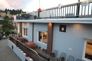 a balcony of a building with tables and chairs at Himalayan view stay - Pahado wala ghar in Mussoorie