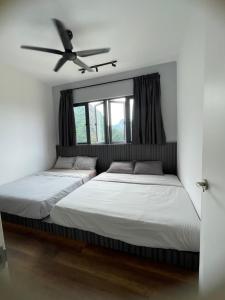 two beds in a bedroom with a ceiling fan at Sunway City Ipoh Tambun Onsen Cozy Retreat 8pax in Tambun +43 photos